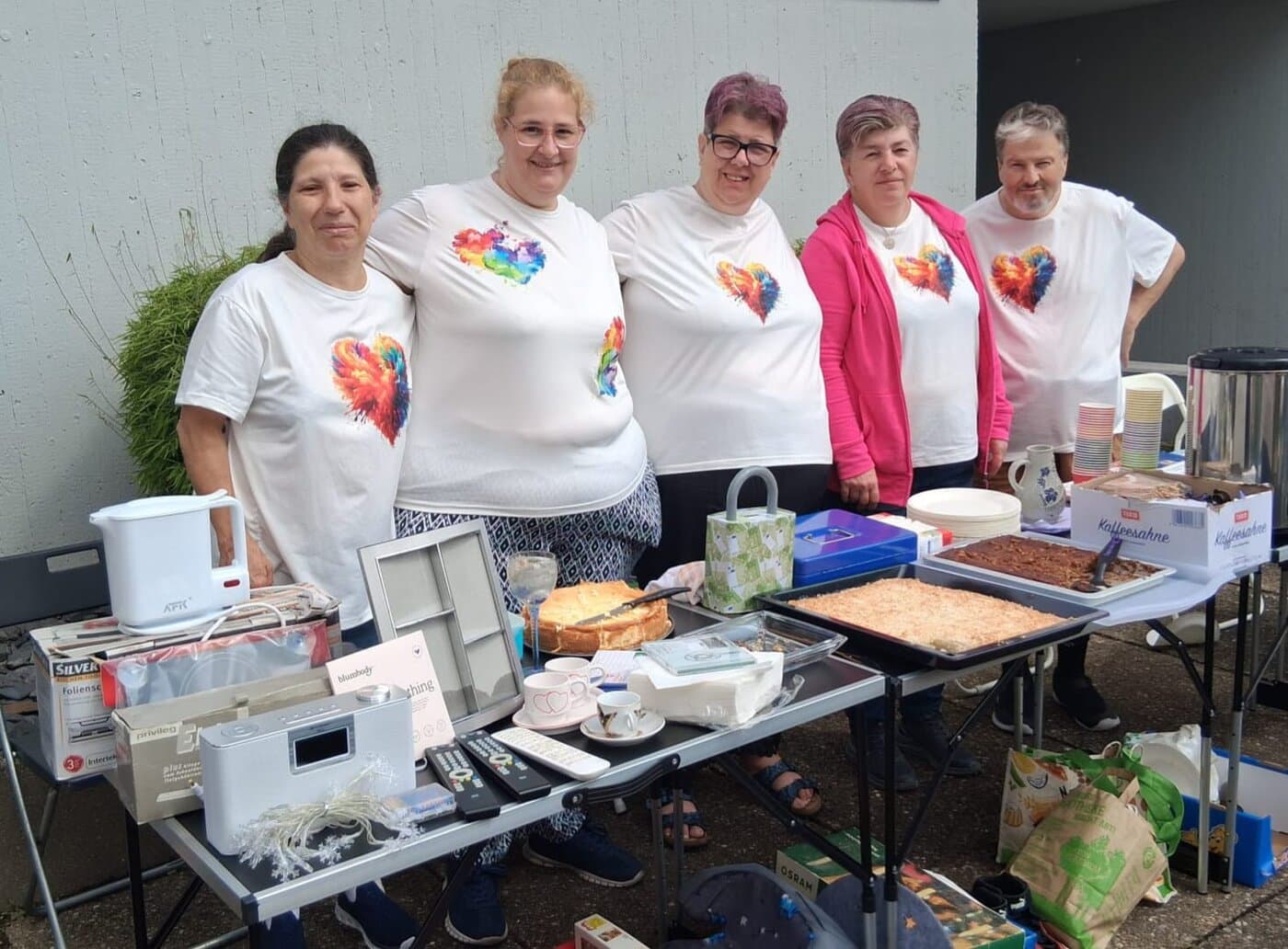 Das Team der Sozialen Herzen beim Flohmarkt — Tische mit Waren, Kaffee und selbstgebackenem Kuchen
